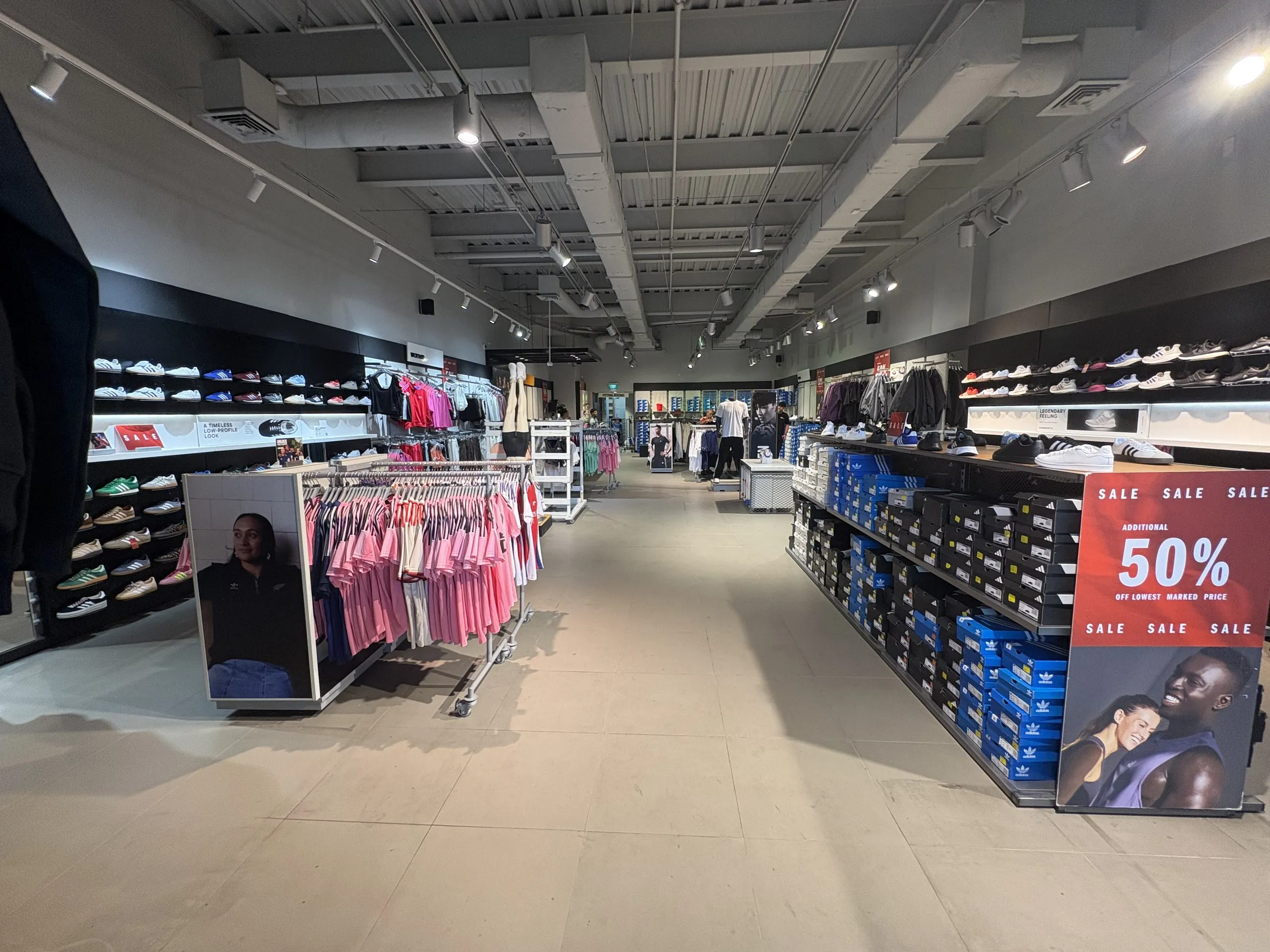 Adidas sales floor before strip-out, with clothing racks, shoe walls and display tables still in place.